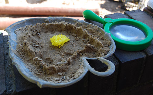 Sand pie with magnifying glass